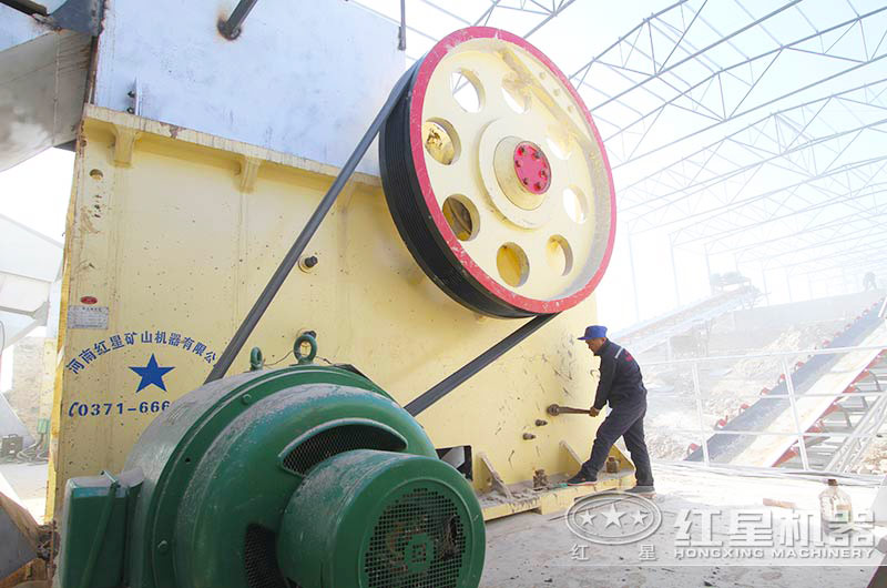 顎式破碎機(jī)生產(chǎn)現(xiàn)場(chǎng)，紅星工作人員正對(duì)設(shè)備進(jìn)行檢修